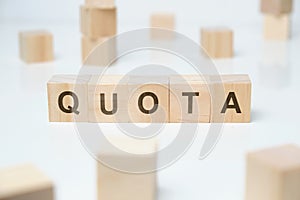 Modern business buzzword - quota. Word on wooden blocks on a white background