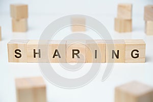 Modern business buzzword - sharing. Word on wooden blocks on a white background