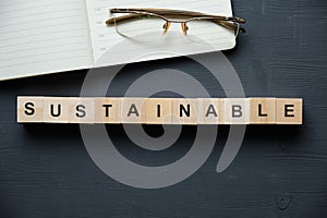 Modern business buzzword - sustainable. Top view on wooden table with blocks. Top view