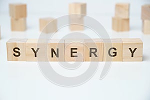 Modern business buzzword - synergy. Word on wooden blocks on a white background