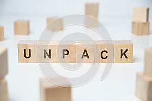 Modern business buzzword - unpack. Word on wooden blocks on a white background