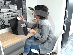 Modern business caucasian woman sticking a note on her laptop