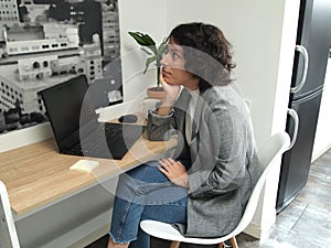 Modern business caucasian woman thinking while is sitting in front of her laptop