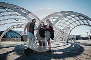 Modern business colleagues meeting outdoors under urban architecture