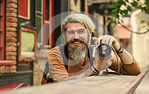 Modern business. Old technology. Professional photographer use vintage camera. Photography business. Bearded man hipster