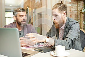 Modern Business People Discussing Work Project in Cafe