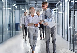 Modern business people have a discussion while walking through the office