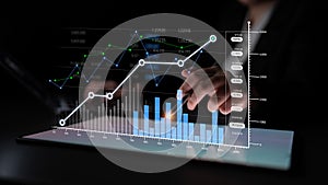 Business analytics and data visualization with futuristic graphic display on tablet featuring hands interacting with
