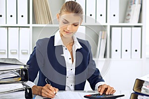 Modern business woman or confident female accountant in office. Student girl during exam preparing. Audit, tax service photo