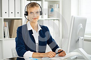 Modern business woman with headset in the office. Customer service operator at home work place. Success start up concept