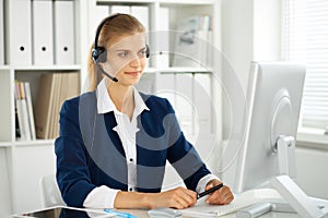 Modern business woman with headset in the office. Customer service operator at home work place. Success start up concept