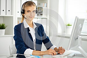 Modern business woman with headset in the office. Customer service operator at home work place. Success start up concept