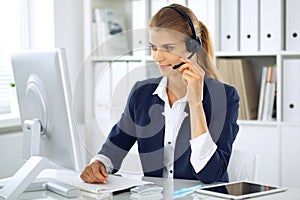 Modern business woman with headset in the office. Customer service operator at home work place. Success start up concept