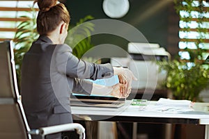 modern business woman in modern green office stretching hand