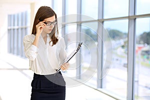 Modern business woman standing and keeping papers in the office with copy space area