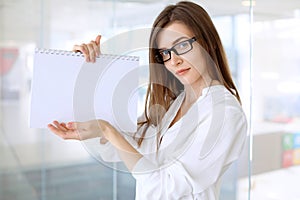 Modern business woman standing and keeping papers in the office with copy space area