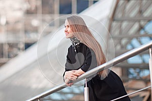 Modern business woman standing near modern office building