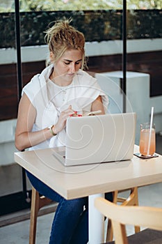 Modern business woman working laptop computer at coffee shop interior, internet distance work