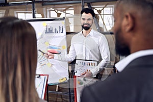 Modern businessman conducting a presentation while having staff meeting in the board room