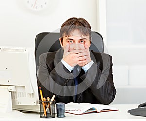 Modern businessman making speak no evil gesture