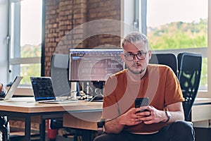 A modern businessman takes a relaxing break from work, using his smartphone to unwind and recharge during his pause