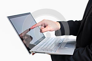 Modern businessman wearing a black suit. Holding a computer or l