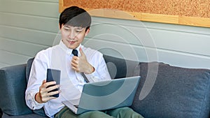 Modern businessmen lie down on lobby couch for casual relaxation by stretching legs and working with comfortable laptops for