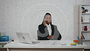 Modern businesswoman creative concept. Woman at the desk talking on the phone, smiling showing thumbs up, looking at the
