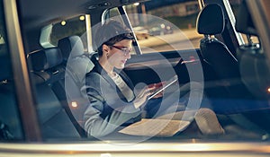 Modern businesswoman working late in car