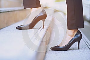 Modern businesswoman working woman close-up legs walking up the stairs