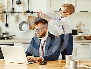 Modern busy man working remotely at home with playful kid