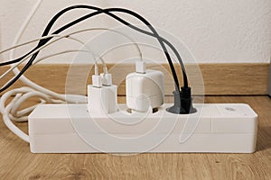 Modern cable connector for overloaded power boards at home. The extension cord is filled with sockets