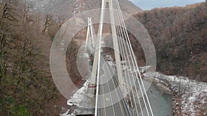 modern cable-stayed bridge for automobiles in mountain area, aerial view at winter day