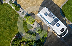 Modern Camper Van with Solar Panels Installed Staying on Residential Driveway Aerial View