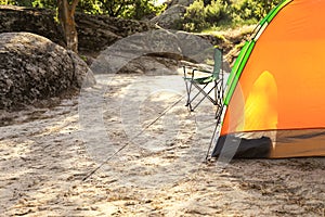 Modern camping tent and chair in wilderness