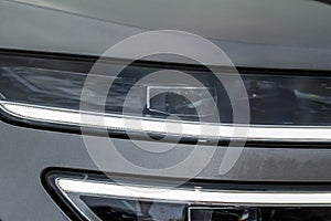 Modern car headlight close up view.