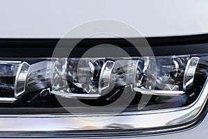 Modern car headlight close up view.