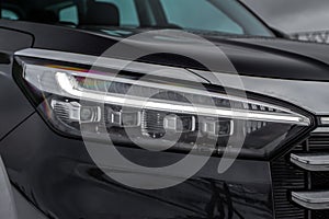 Modern car headlight close up view.