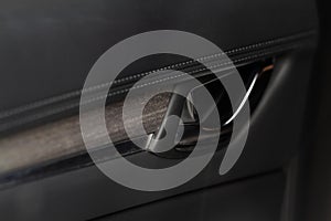 Modern car interior door handle close up.