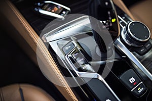 Car Interior: Details of Modern Center Console with Dials, Buttons and Gear knob photo