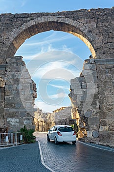 Car passes through the ancient Vespasian Gate in Side, Turkey