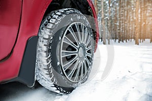 Modern car on snowy road in winter forest, closeup