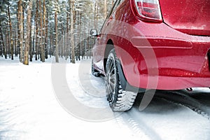Modern car on snowy road in winter forest. Space for text