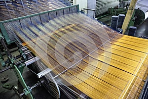 Modern Carpet weaving factory. Carpet making machine needle. Yarn bobbins attached to a carpet weaving machine. Inside Interior of