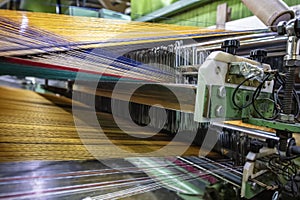 Modern Carpet weaving factory. Carpet making machine needle. Yarn bobbins attached to a carpet weaving machine. Inside Interior of