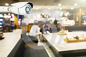 security Modern CCTV camera on a wall, A blurred coffee shop background photo