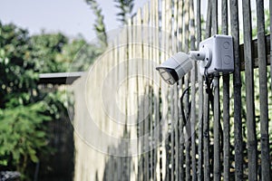 Modern CCTV security system on the background of a wooden wall in the garden. Smart camera theft protection