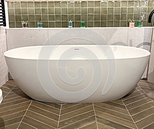 Modern ceramic bathtub . White tub in minimalistic bathroom interior.