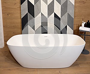 Modern ceramic bathtub . White tub in minimalistic bathroom interior.