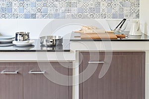 Modern ceramic kitchenware and utensils on the black granite countertop